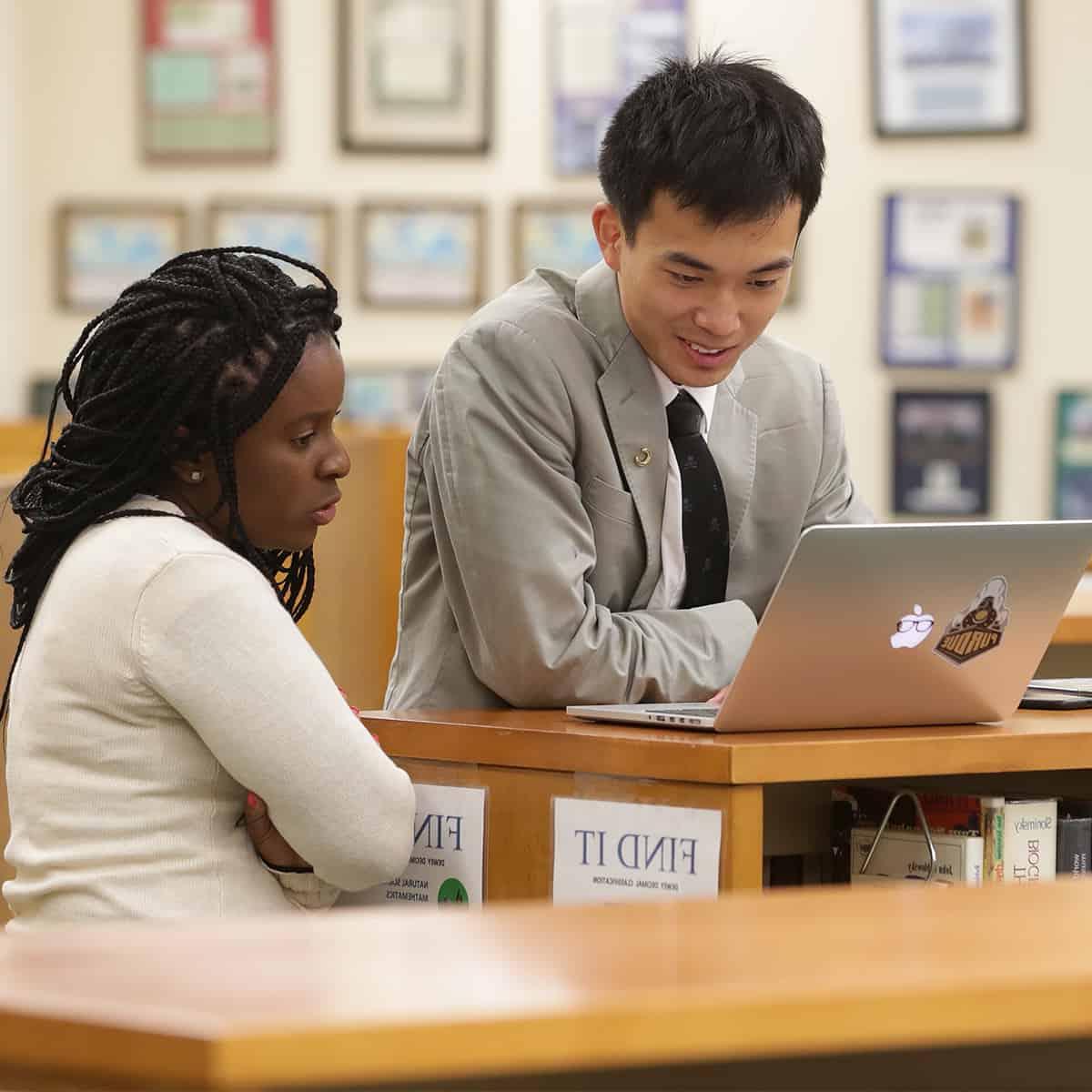 Student working with a teacher in the library